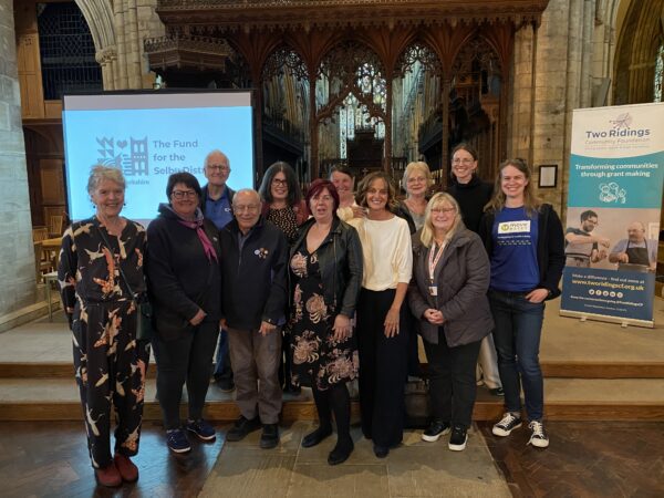 A group of people standing together inside an Abbey.