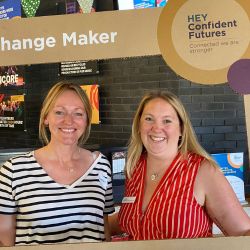 Two women standing together a smiling at the camera