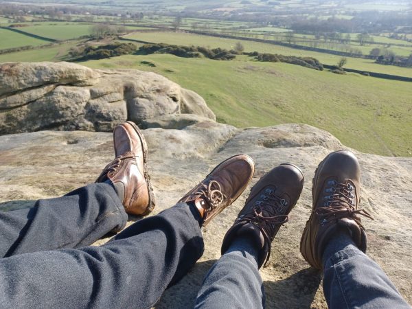 Two people with walking boots on over looking Yorkshire 